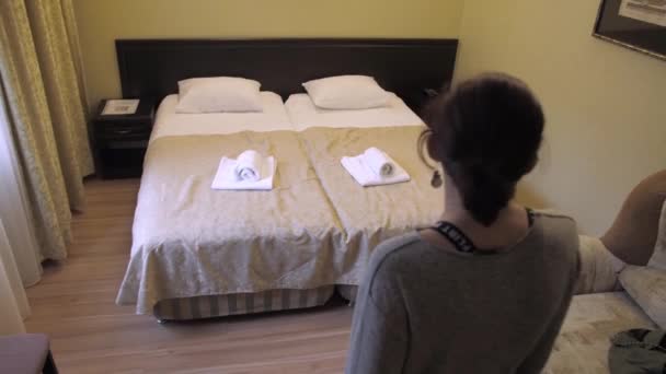 침대에는 머리의 소녀가 여행자는 하루를 보내고 침대에서 내린다 — 비디오