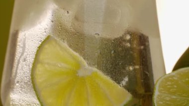 Kokteyl sisli bir bardağa doldurulur ve bardağa serinletici tropikal bir içecek damlatılır. Buzların arasından yaz içeceğine eklenen kireç parçalarını görebilirsiniz.