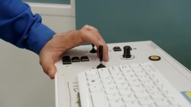 Bir adamın eli kontrol sistemini bir kontrolörle kontrol eder.
