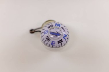 Close up of a pin on style ball compass. Isolated on a white background. Selective focus, background blur and foreground blur.