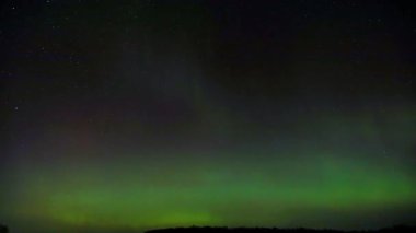 Aurora Borealis 'in 12 Kasım 2025' te St. Croix County, Wisconsin 'deki zaman kaydında. Kırmızı, yeşil ve mavi kuzey ışıkları ve yıldızlar gece gökyüzünü aydınlatır..