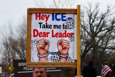 Fort Snelling, MN, ABD 15 Ocak 2026: Yakın çekimde, ICE karşıtı bir miting sırasında siyasi protesto işareti tutan bir kişi görülüyor. Kırmızı ve mavi yazılı yazı ve kelepçeli ellerin bir çizimi Hey ICE beni Sevgili Leade 'e götür diyor.