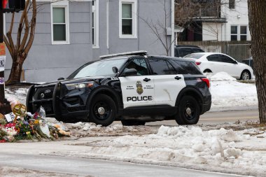 Minneapolis, MN, ABD 15 Ocak 2026: Minneapolis Polis Departmanı, bir federal ICE ajanı tarafından vurularak öldürülen Renee Good için büyük bir toplum anıtı haline gelen bölgeye park etti..