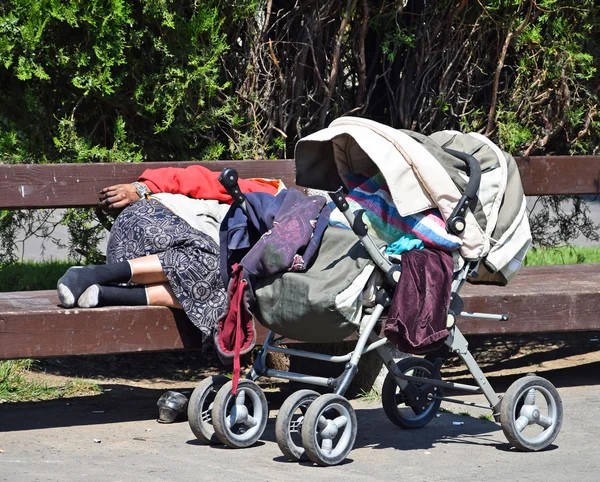 Mujer sin hogar está durmiendo en un banco del parque — Foto de Stock