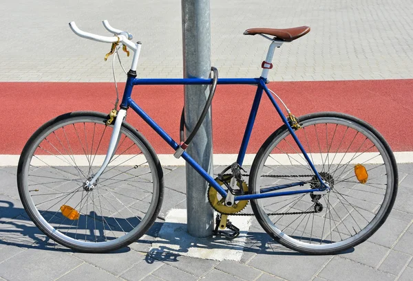 Bicyclette enchaînée à un poteau métallique — Photo