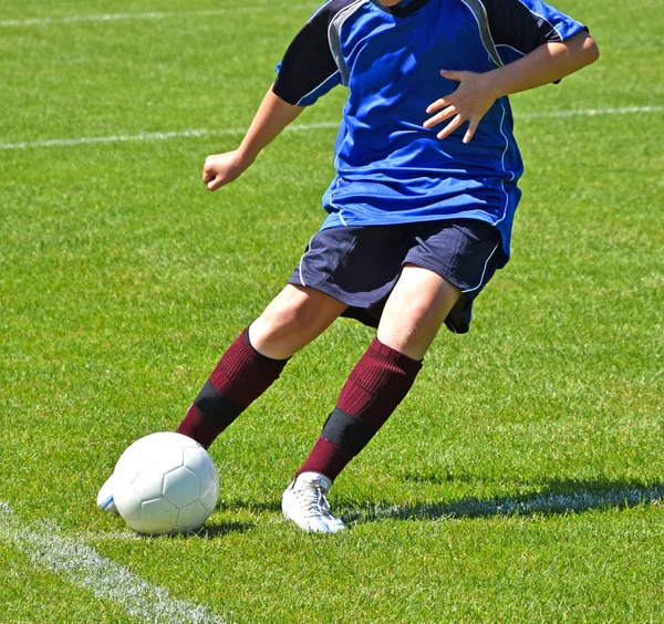Dziecko kopie piłkę — Zdjęcie stockowe