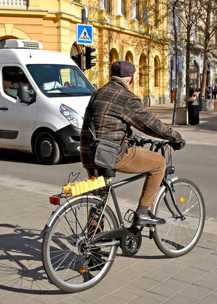 Bisikletli yaşlı adam şehir caddesinde