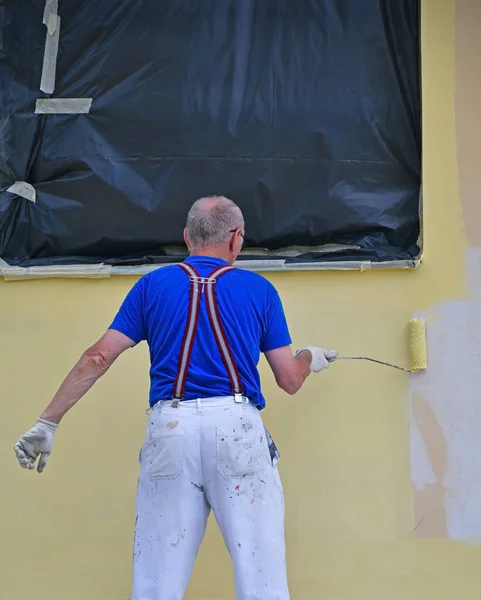 Człowiek Maluje Ścianę Budynku — Zdjęcie stockowe