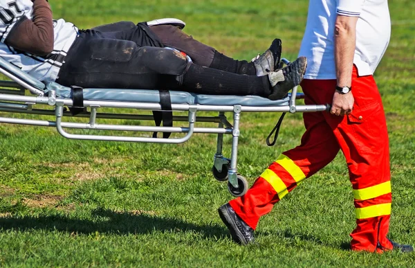 Medic helps to the injured football player — Stock Photo, Image