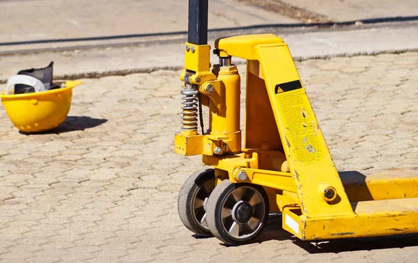 Hydraulický zvedák a pracovní helma — Stock fotografie