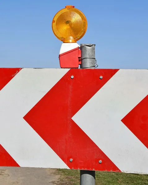 Barrière de route avec panneau fléché et lampe — Photo