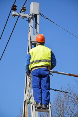 Elektrikçi bir direk üzerinde çalışıyor