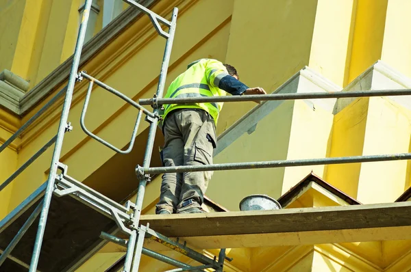 O homem está a trabalhar na restauração de um edifício antigo. — Fotografia de Stock