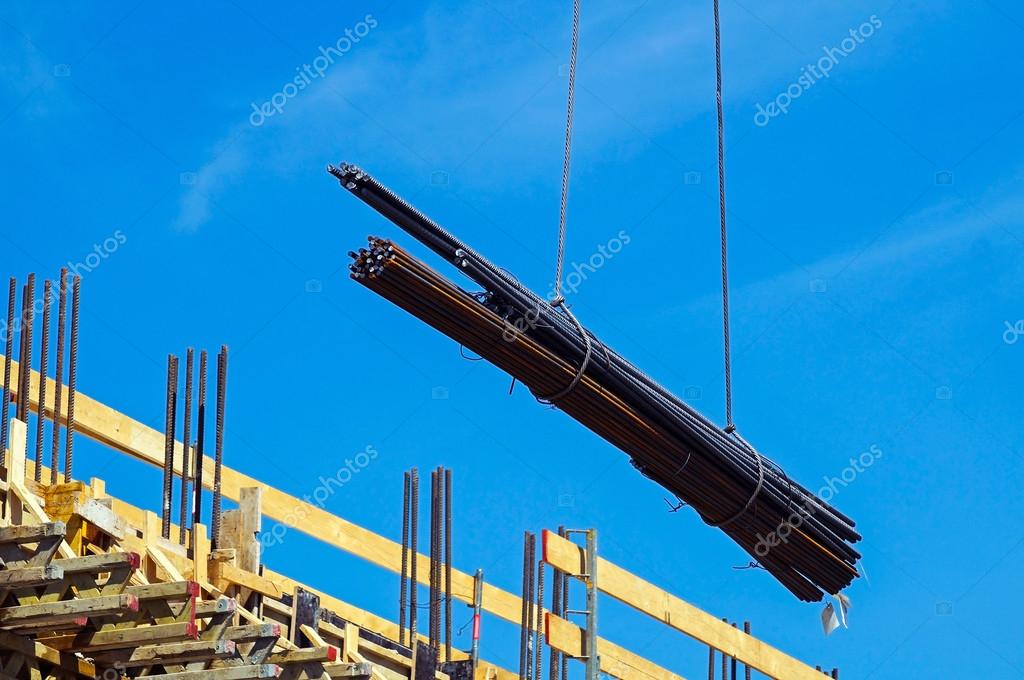 Tower crane is lifting steel rods at the construction site — Stock ...