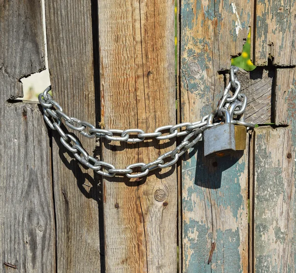 Porta de madeira fechada com corrente e cadeados — Fotografia de Stock