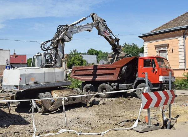 Excavator and truck at the road construction — Stock Photo, Image