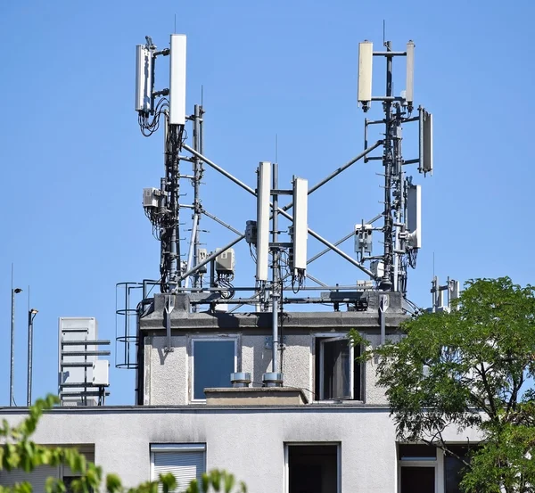 Antennas on the top of an old warehouse building — Stock Photo
