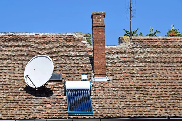 Antenna and solar heater on the roof — Stock Photo, Image