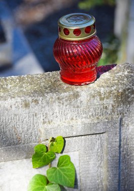 Genel mezarlıkta mezar taşı üzerinde kırmızı fener