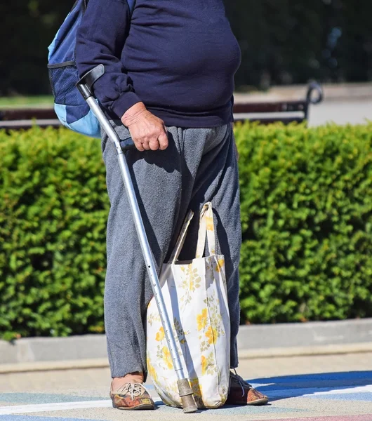 Mulher velha fica com uma bengala na rua — Fotografia de Stock