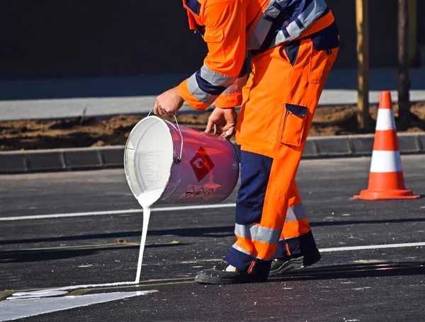 Man is painting road signs on the asphalt — Stock Photo, Image