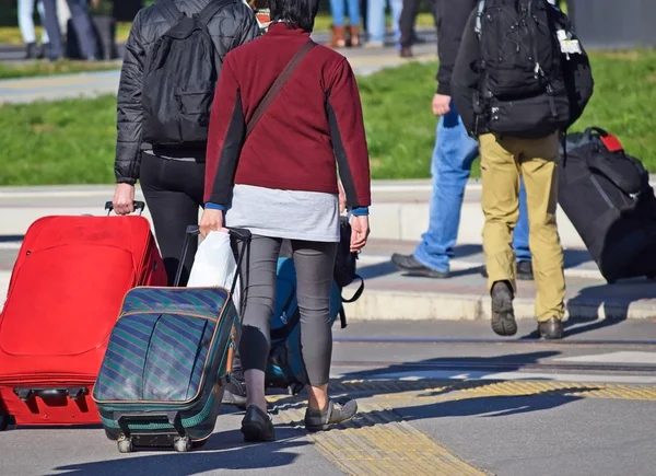 Young people walking with suitcases