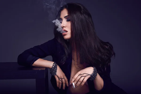 Elegant hot brunette woman smoking a cigarette — Stock Photo, Image