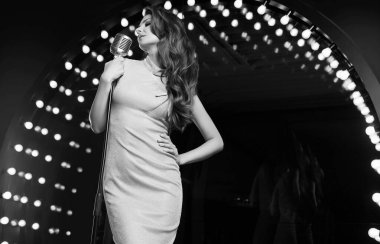 Restoran sahnesinde arka planda retro mikrofonlu zarif elbiseli muhteşem şarkıcı kadın portresi..