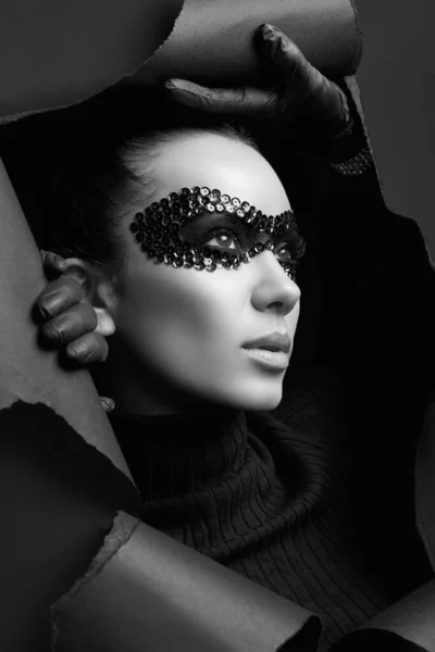 魅力的なエレガントなブルネットの女性の肖像画で黒Turtleeckセーターとスパンコールマスクルックスルーザリッピングスタジオ背景 — ストック写真