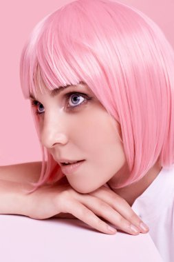 Parlak yaz portresi. Stüdyonun renkli arka planında pembe saçlı güzel bir kız.