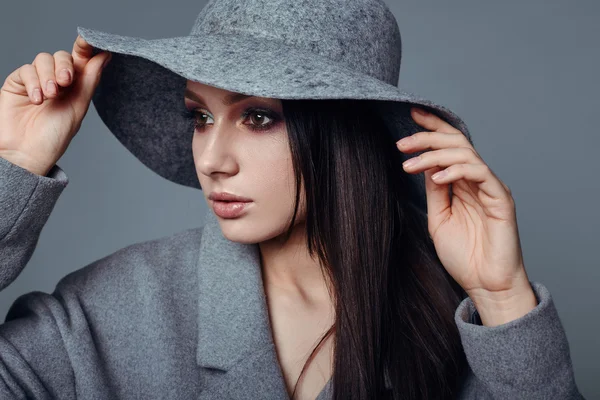 Young fashion brunette woman beauty in gray coat and hat — Stockfoto