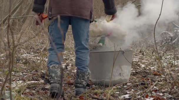 Een Man Giet Brandstof Plastic Afval Een Dakloze Verbrandt Afval — Stockvideo