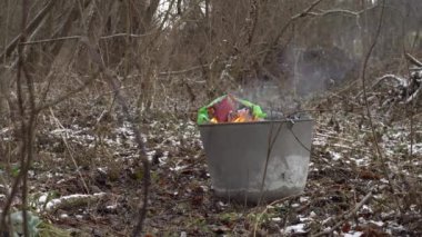  Plastik atıkların yandığı ve çevreyi zehirlediği büyük metal tank.