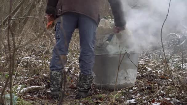 Egy Férfi Egy Zacskó Műanyag Üveget Dob Tűzbe Egy Hajléktalan — Stock videók