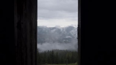 Panorama, ahşap bir evin kapısında güzel bir manzara filme alınır. Dağlar ve orman.
