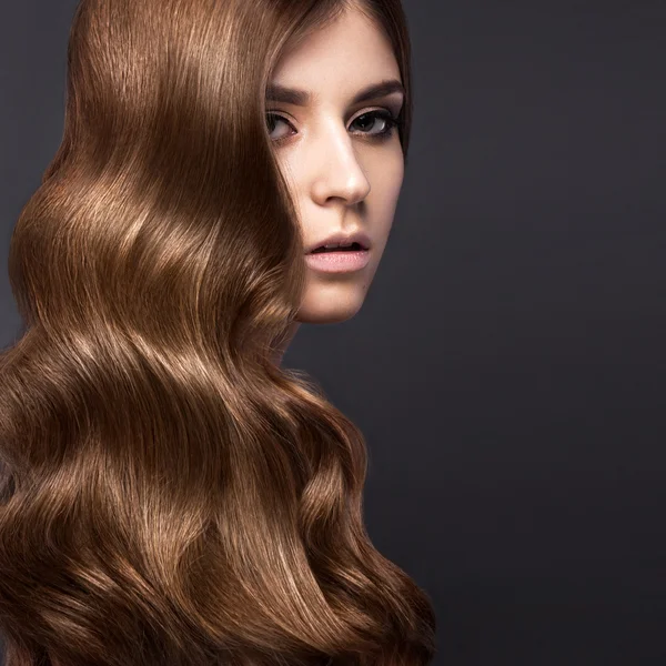 Menina morena bonita com um cabelo perfeitamente cachos e maquiagem clássica. Cara de beleza . — Fotografia de Stock