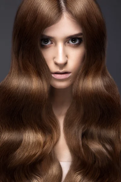 Beautiful brunette girl with a perfectly curls hair and classic make-up. Beauty face. — Stock Photo, Image