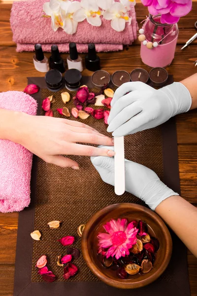 Primeros planos cuidado de uñas por el especialista en manicura en salón de belleza . —  Fotos de Stock