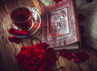 Kompozisyon oluşur gül, hibiscus çay Kupası ve not defteri bir ahşap yüzeye