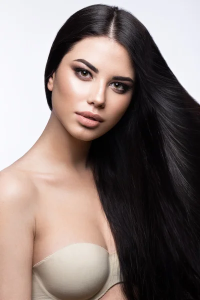 Menina morena bonita em movimento com um cabelo perfeitamente liso e maquiagem clássica. Cara de beleza . — Fotografia de Stock