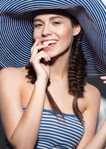 Yaz plaj çizgili şapkalı güzel neşeli kız. Yüz güzelliği.