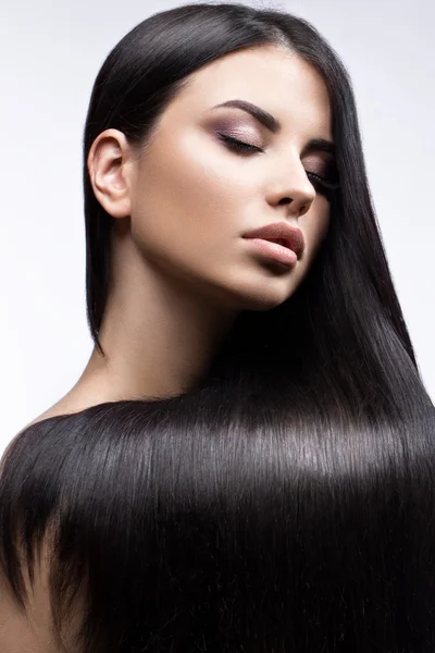 Bella ragazza bruna in movimento con capelli perfettamente lisci e trucco classico. Bellezza viso . — Foto Stock