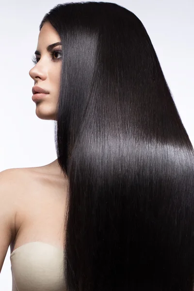 Menina morena bonita em movimento com um cabelo perfeitamente liso e maquiagem clássica. Cara de beleza . — Fotografia de Stock