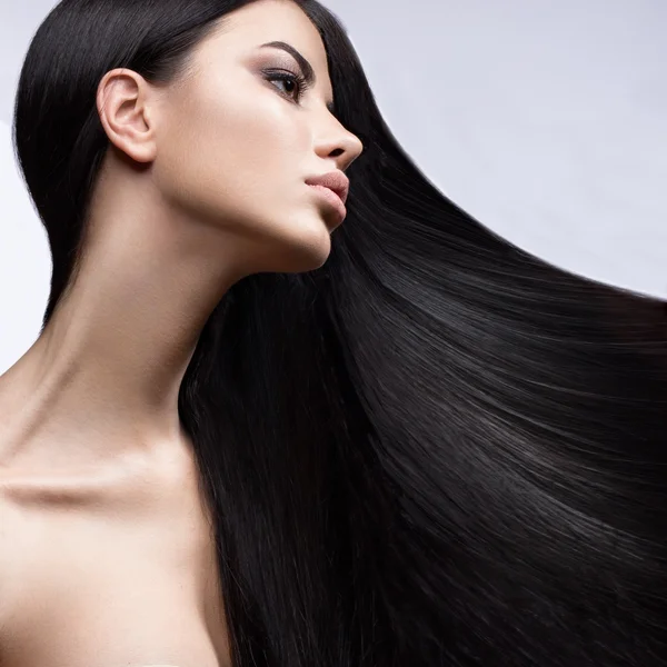 Menina morena bonita em movimento com um cabelo perfeitamente liso e maquiagem clássica. Cara de beleza . — Fotografia de Stock