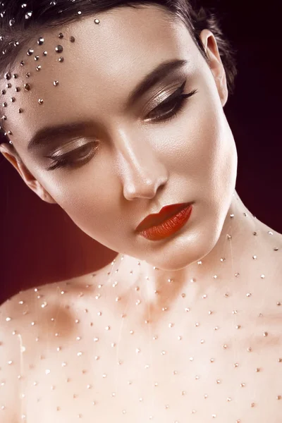 Porträt eines schönen Mädchens mit hellem Make-up und Kristallen auf dem Körper. Schönheit Gesicht. — Stockfoto