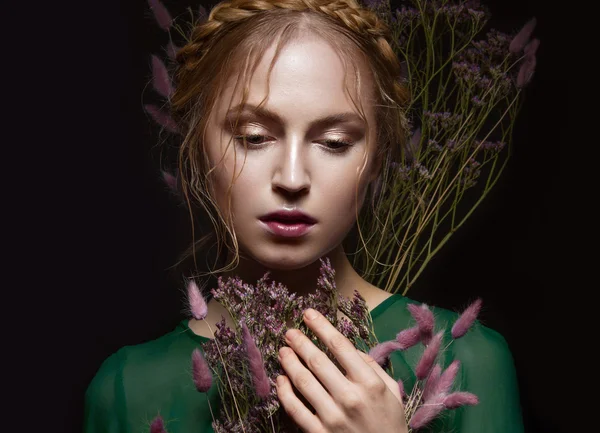 Beautiful girl with a gentle make-up, hairstyle  in the form of braids,  dry flowers, green dress. Beauty face. — Stock Photo, Image