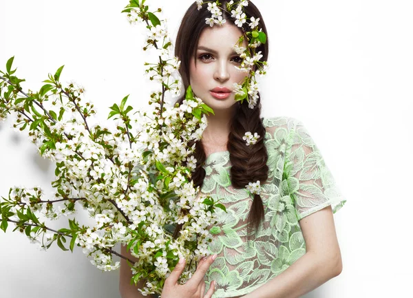 Schöne brünette Mädchen in grünem Sommerkleid mit sanftem romantischem Make-up, rosa Lippen und Blumen in der Hand. die Schönheit des Gesichts. — Stockfoto