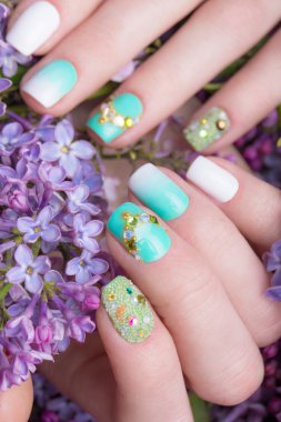 Güzel turkuaz manikür el üzerinde kristalleri ile. Yakın çekim.