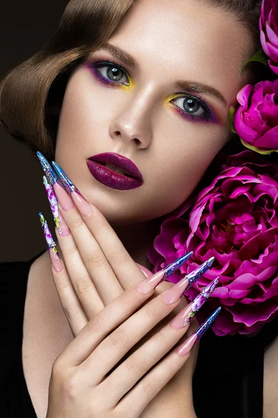 Bella ragazza con trucco colorato, fiori, acconciatura retrò e unghie lunghe. Design della manicure. La bellezza del viso . — Foto Stock