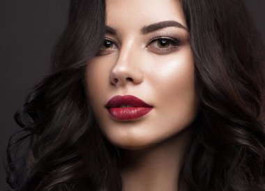 Güzel esmer model: bukleler, klasik makyaj ve kırmızı dudaklar. Güzel yüz..
